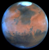 Mars photographie par Hubble le 25 Fvrier 1995  103 millions de kilomtre de distance. Les halos blancs  gauche sont des nuages d'eau de glace. Noter Ascraeus Mons, le point brun  gauche prs du limbe. Le Mridien Central se situe  29. Document NASA, P.james (U.Toledo) et S.Lee (U.CO).