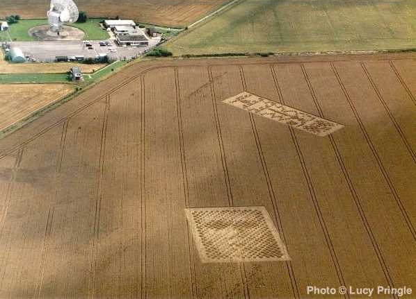 Crop circles découverts à Chilbolton, Hampshire, le 21août 2001. On reconnaît le message SETI d'Arecibo  au second plan.